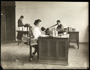 Interior view of a woman typing from a dictating machine and a man dictating into another at the Edison Phonograph Co., West Orange, New Jersey